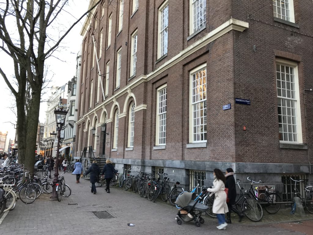 a group of people walking on a sidewalk with bicycles