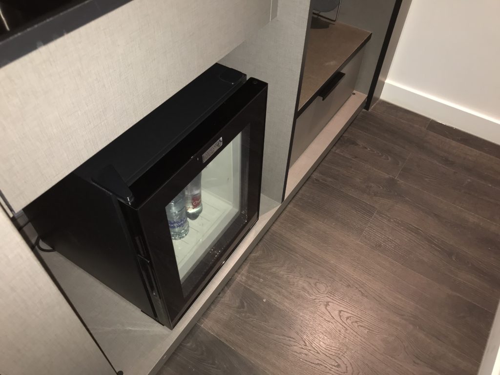 a small black mini fridge with a glass door