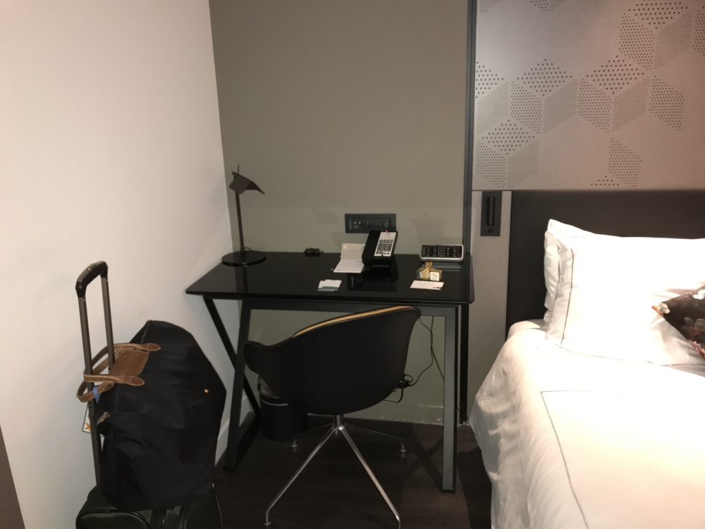 a desk with a chair and a lamp in a hotel room