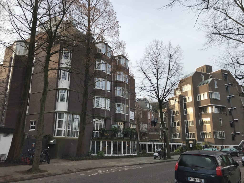 a building with trees and cars on the street