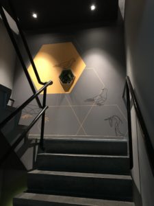 a staircase with a wall and a yellow hexagon on the wall