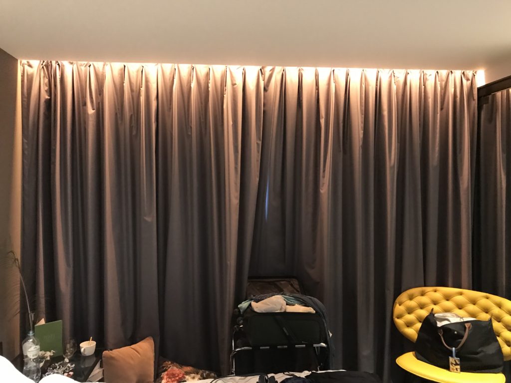 a room with a curtain and a yellow chair