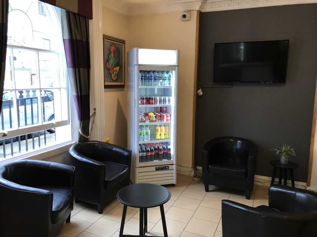 a room with a cooler and chairs