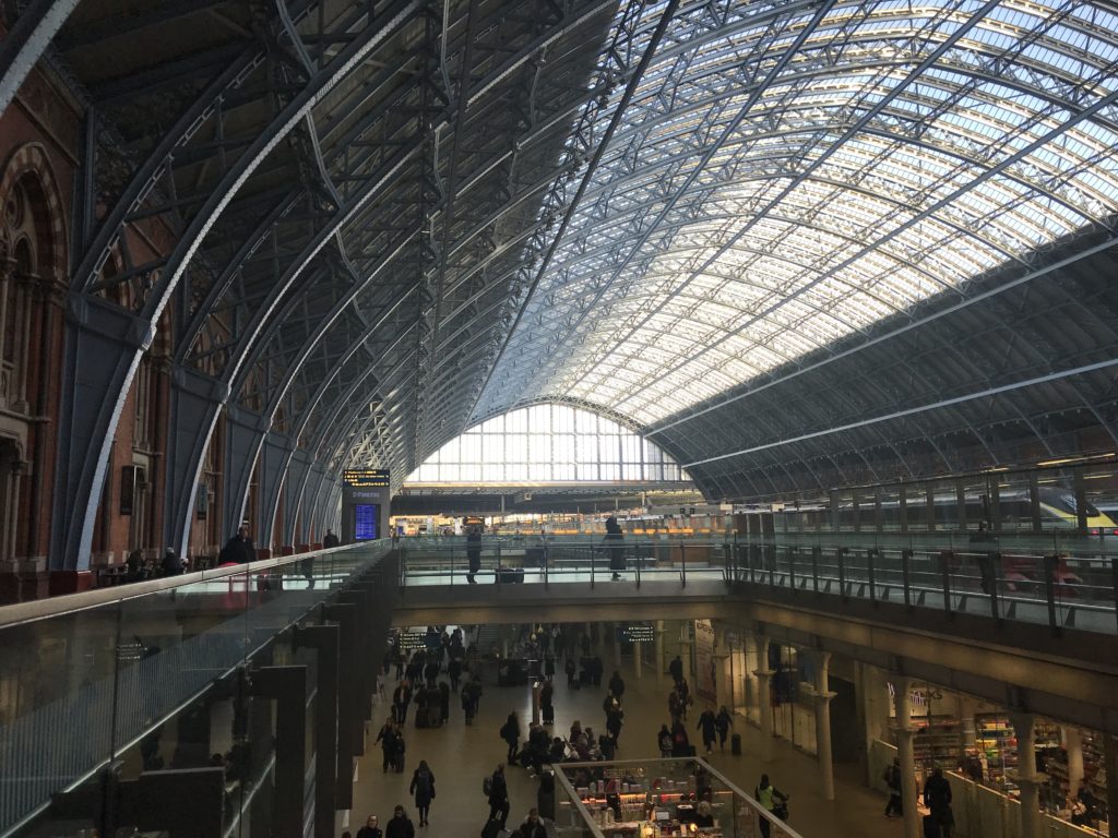 a large building with glass roof with St Pancras railway station in the background