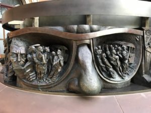 a statue of a person's face with a group of people