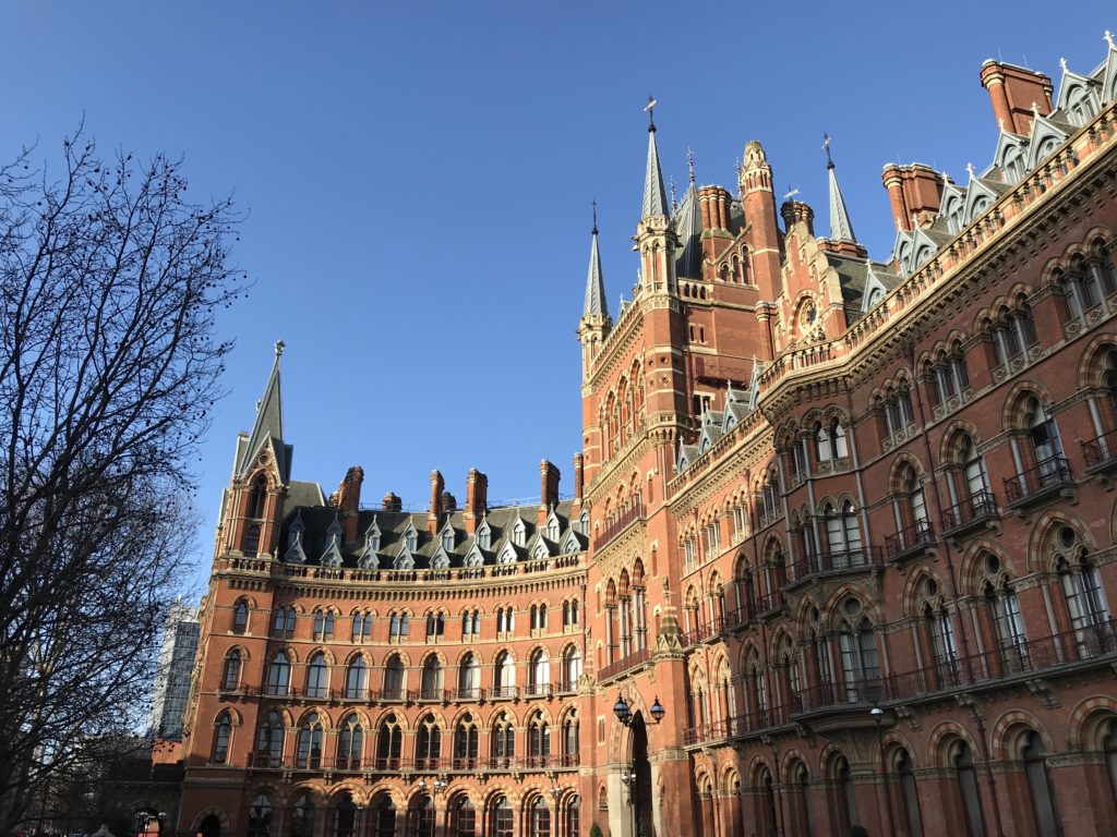 a large brick building with many windows with St Pancras railway station in the background