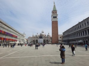 a group of people in a plaza with Piazza San Marco in the background