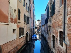 a canal between buildings with a boat