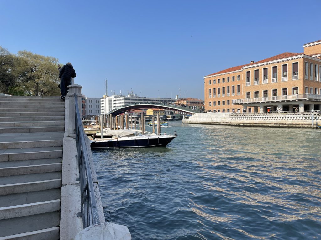 a person standing on a staircase overlooking a body of water