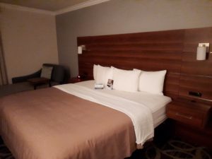 a bed with white pillows and a brown headboard