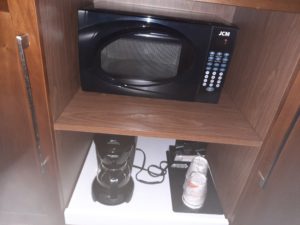 a microwave and coffee maker in a shelf