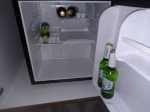 a mini fridge with bottles of beer