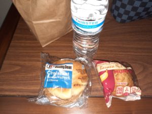 a bagel and a bottle of water on a table