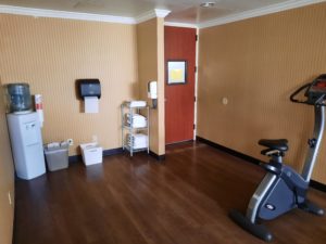 a room with a treadmill and a wood floor