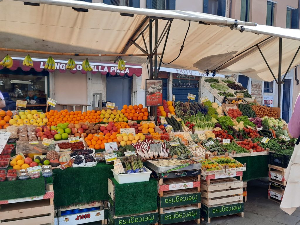 a fruit stand with a white awning