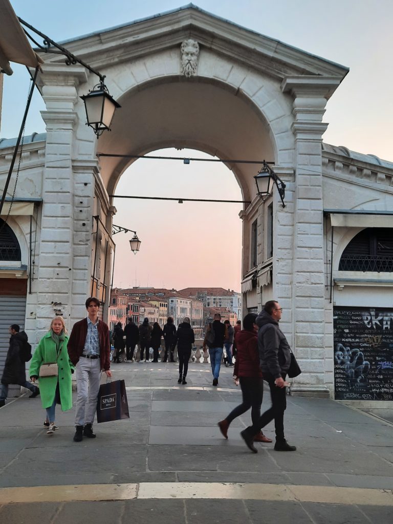 a group of people walking under a archway