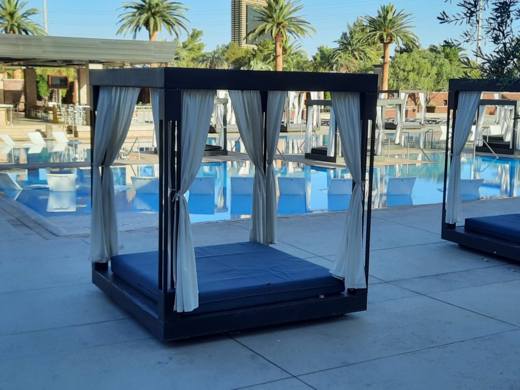 a pool with a bed and a pool in the background