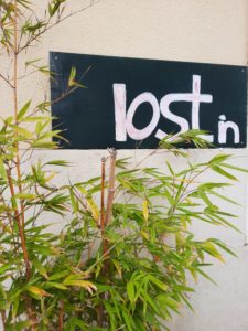 a sign with a plant in front of it