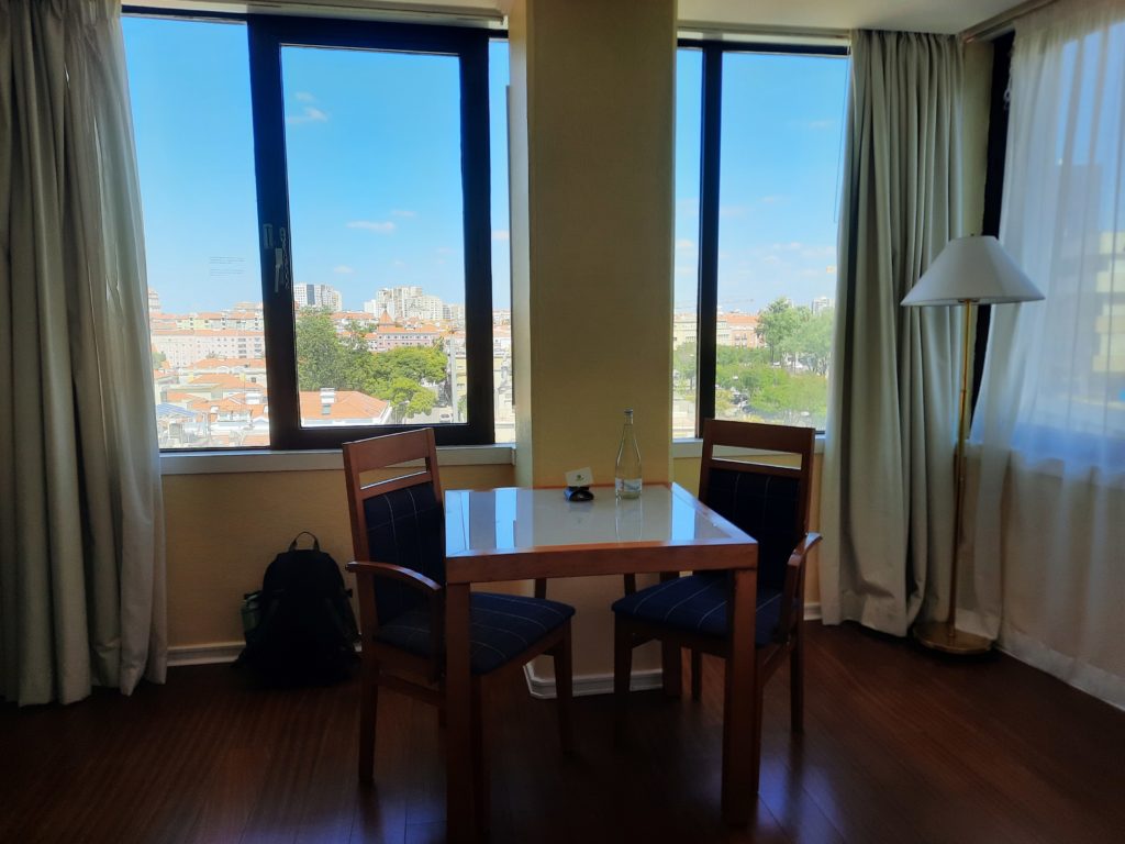 a table and chairs in a room with windows and a city view