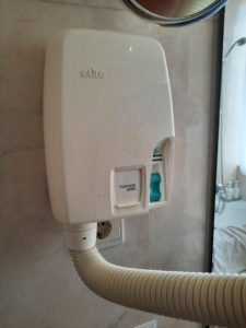 a white soap dispenser on a wall