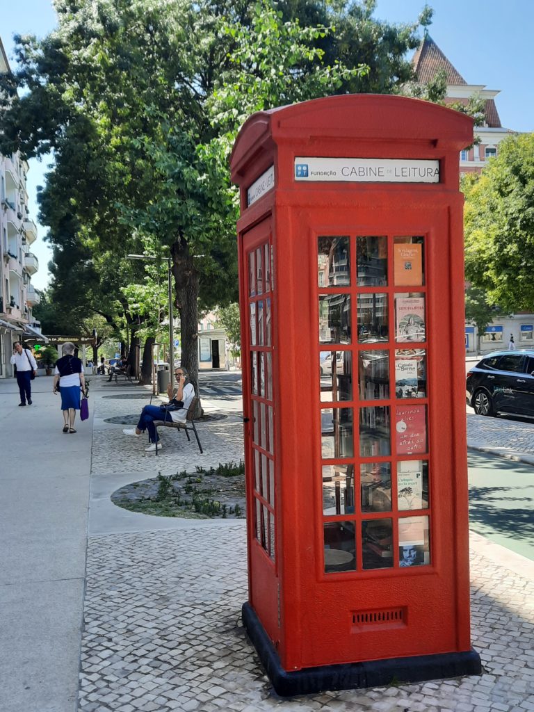a red telephone booth on a sidewalk