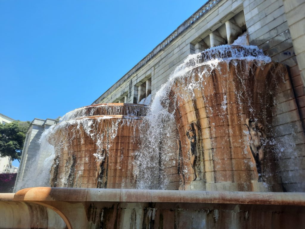 a water fountain with a stone wall