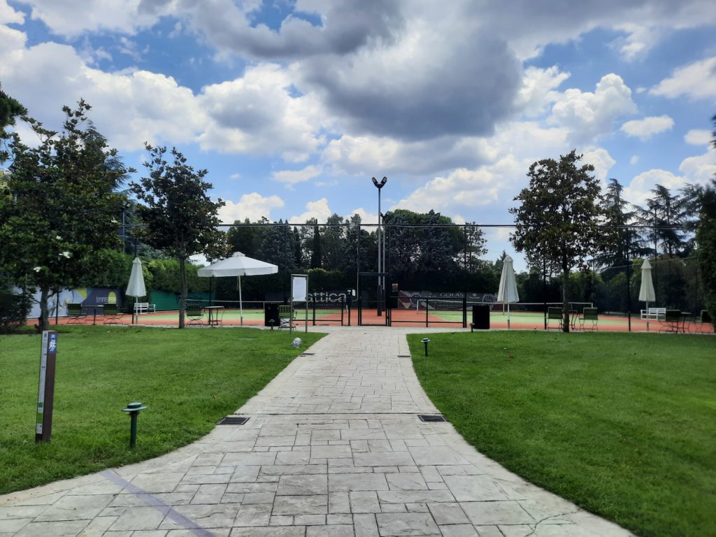 a tennis court with a fence and trees