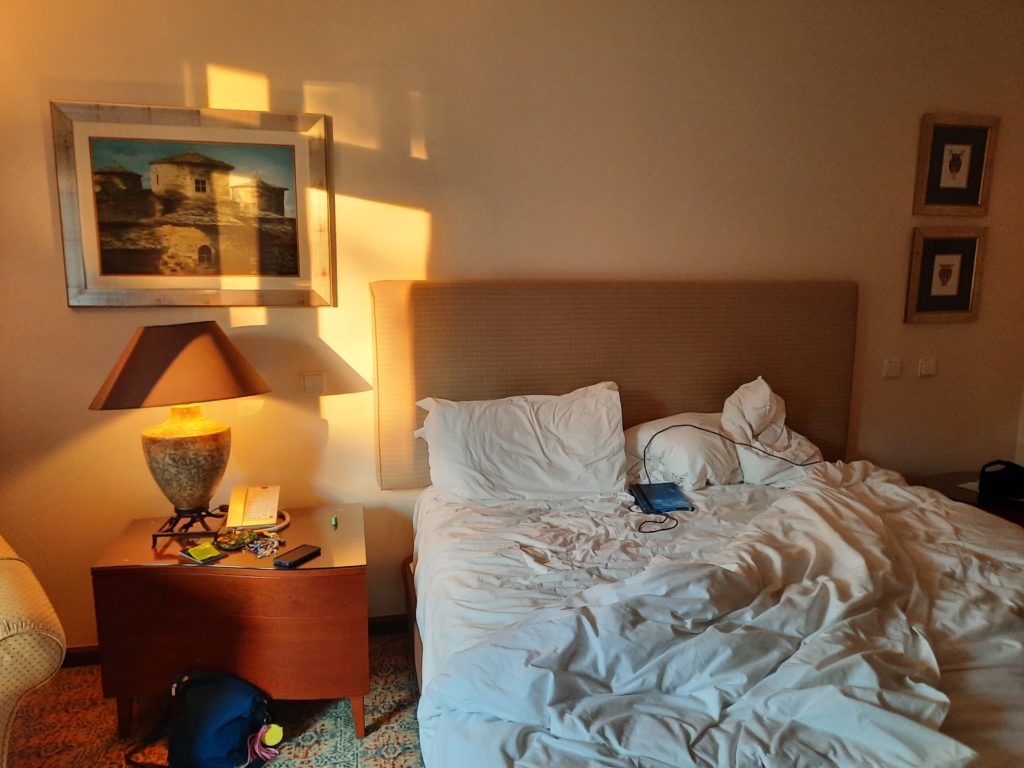 a bed with a lamp and a picture on the wall