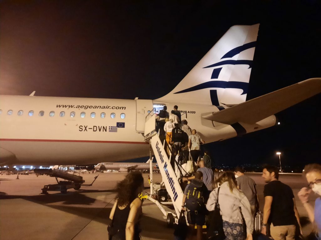 people boarding an airplane at night