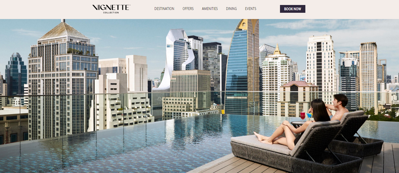 a woman sitting on a couch in front of a pool with a city in the background