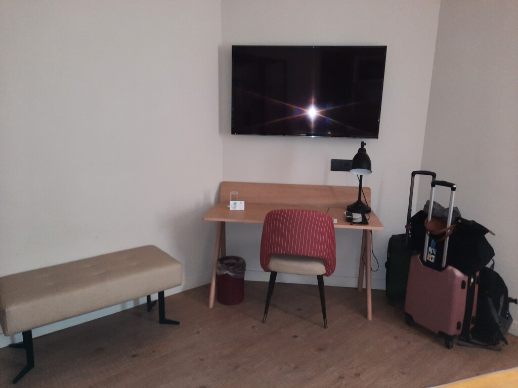 a desk and chair in a room with luggage
