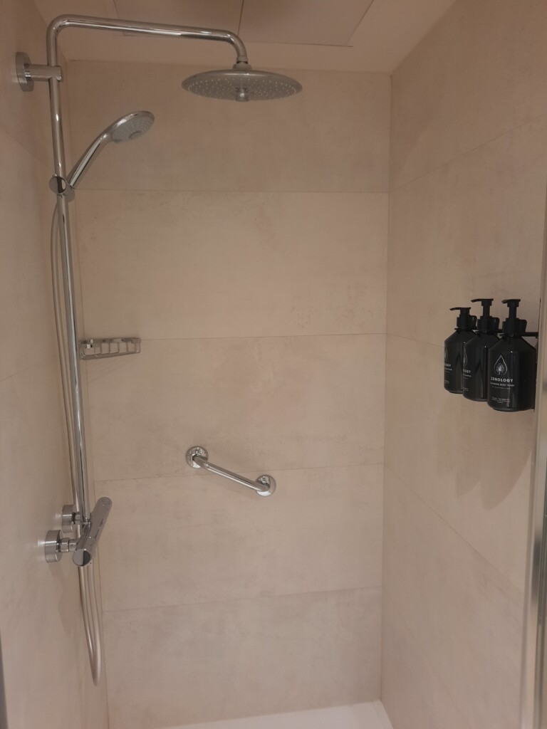 a shower with a shower head and black soaps