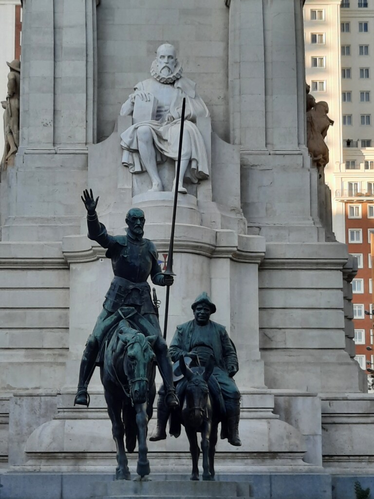 a statue of a man on a horse and a man sitting on a horse