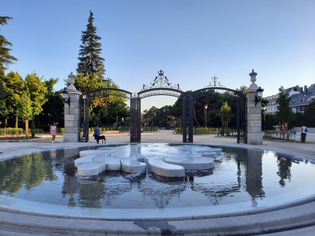 a fountain with a stone sculpture in the middle of a park