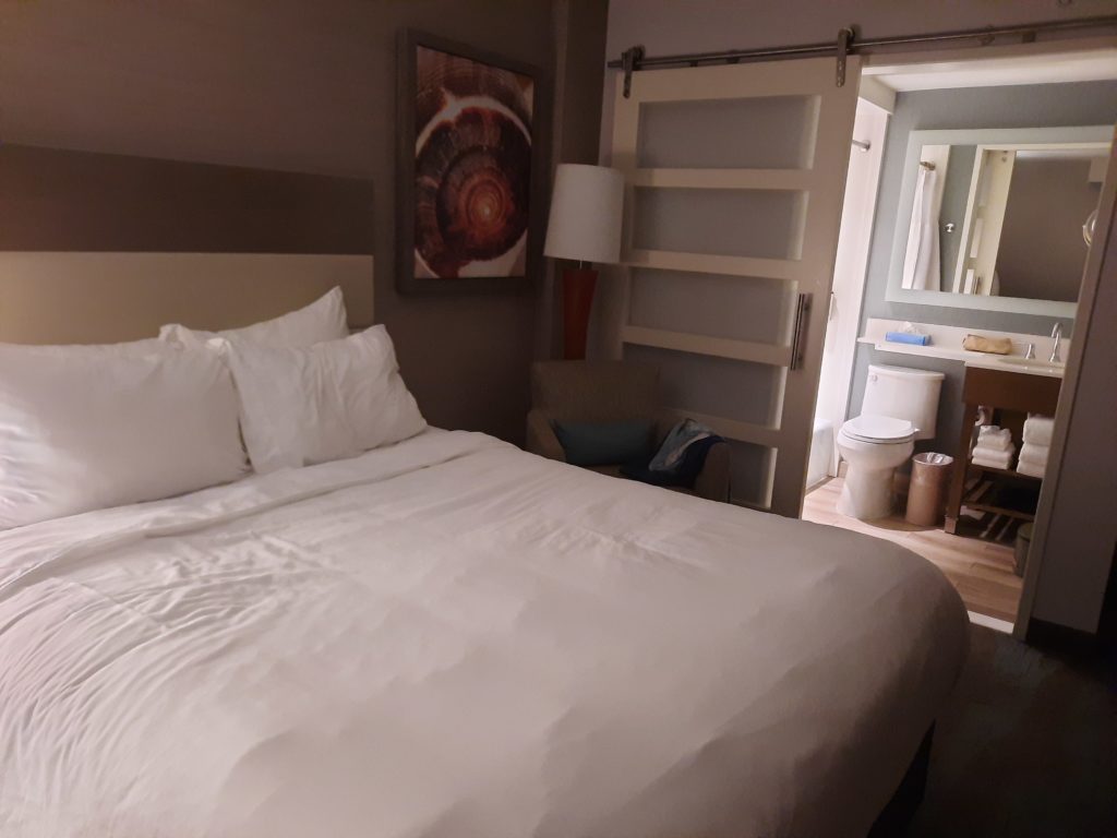 a bed with white sheets and a white towel