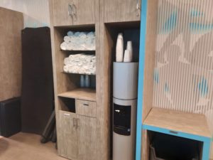 a shelf with towels and a water cooler