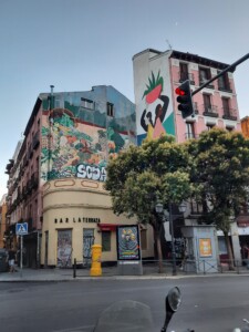 a street light with a building painted on the side