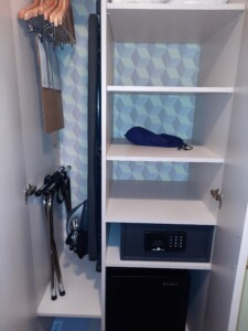 a white shelving unit with a blue and white wallpaper