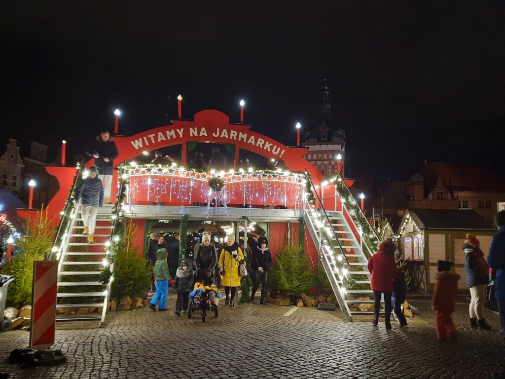 a group of people standing in front of a red building with lights