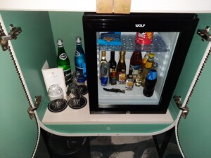 a small mini fridge with bottles of alcohol