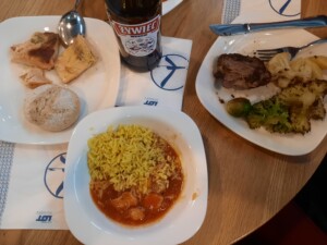 a table with plates of food and a bottle of beer