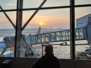 a woman looking out a window at an airport