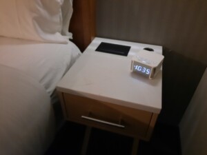 a white alarm clock on a nightstand