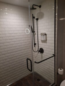 a shower with a black handle