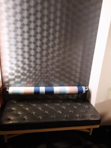 a black bench with a striped roll of paper on it