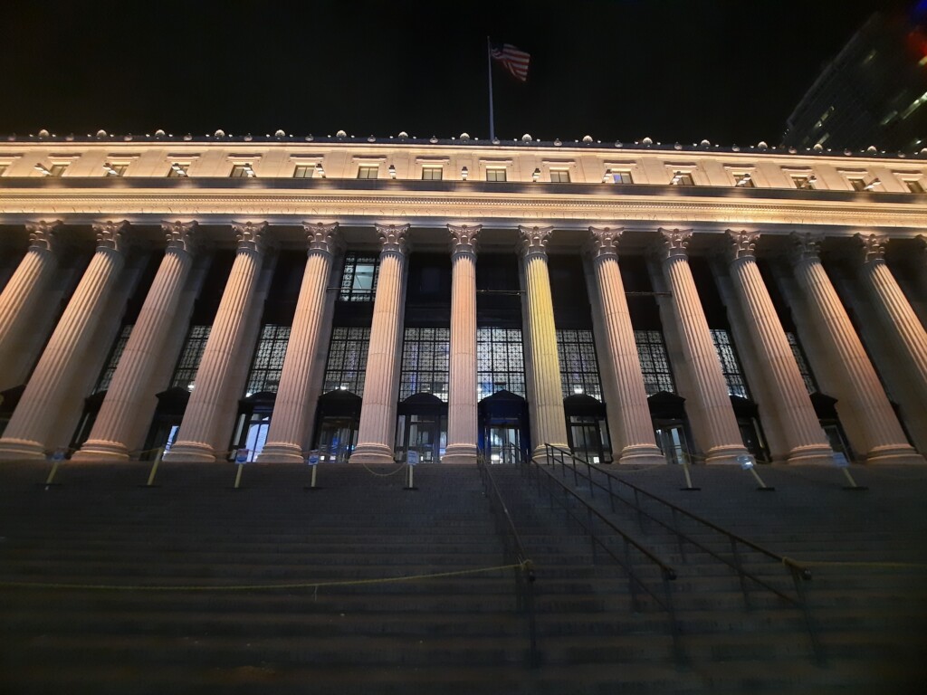 a building with columns and a flag on top