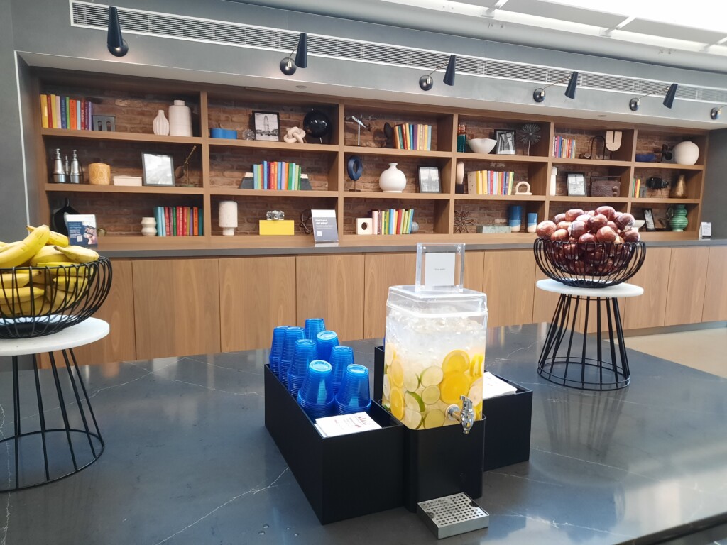 a counter with a drink dispenser and shelves with books