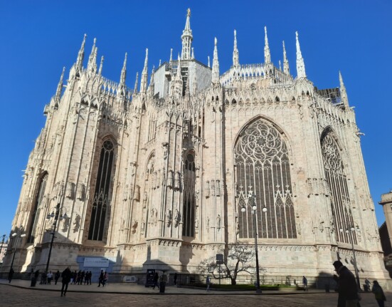 a large white building with many spires with Milan Cathedral in the background