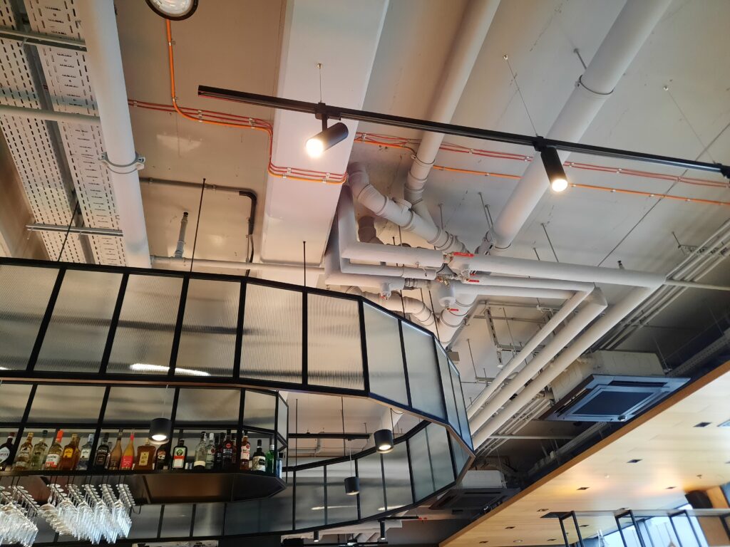 a bar with a glass shelf and white pipes