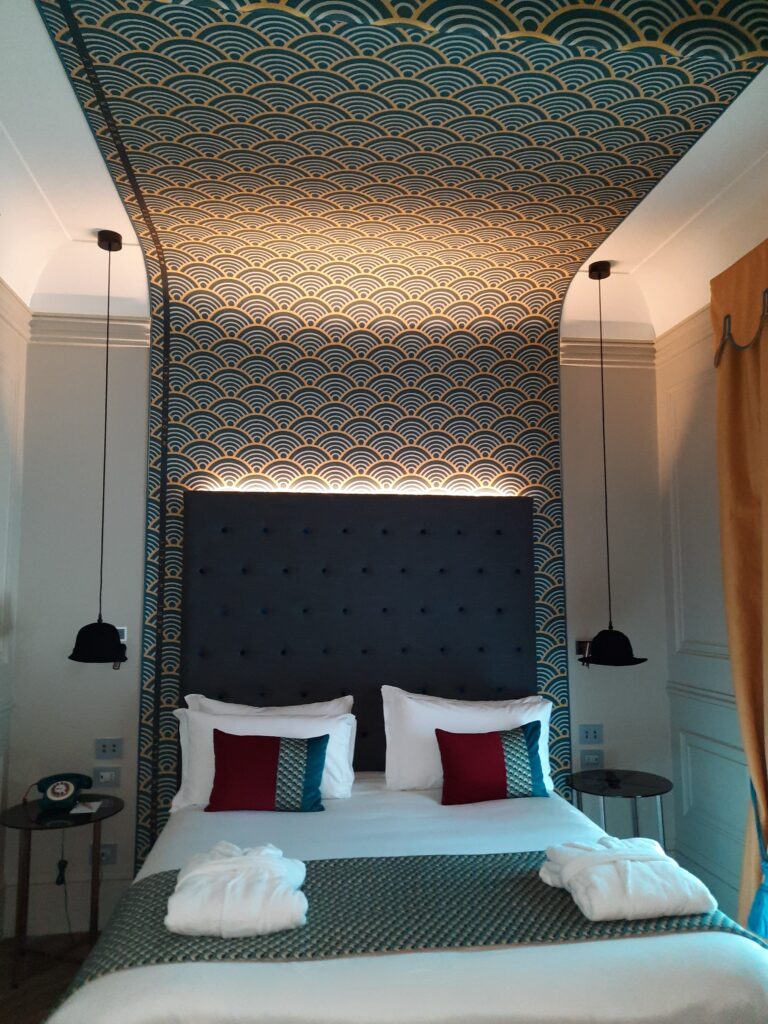 a bed with a wallpaper and lamps